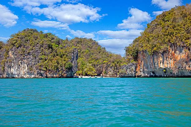 Limestone cliffs and blue sea in Krabi Thailand with a small beach during daytime