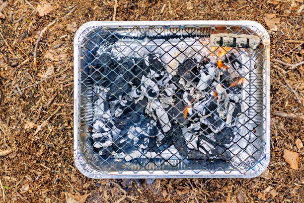 Disposable cheap aluminum grill with burning coals. View from above. High quality photo