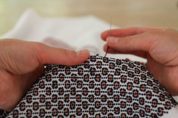 Hands of embroiderer during embroidery work.
