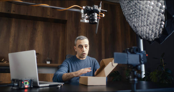 istock Social media influencer making a video about some product in his studio. Advertisement, content creation and marketing concept. 2192935931