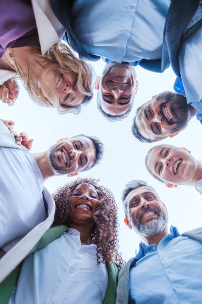 istock Group of businesspeople smiling in a huddle outdoors.Vertical 2192942019