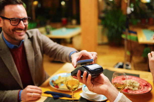 istock Happy customer paying restaurant bill with contactless mobile payment technology 2192943197