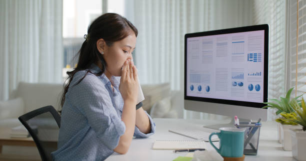istock Asia people young lady remote workforce work on leave day got bad cold flu covid cough blow running nose on tissue paper sit on desk at home office. Tired unwell female freelance staff stress pain. 2192948124