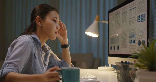 istock Asia people young woman study hard overnight bored remote learn online read data tired busy sit at home office desk workplace drink energy tea coffee cup thinking worry in job tough stress workforce. 2192948176