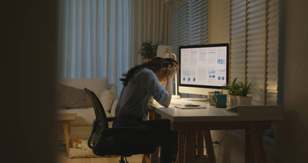 istock Asia people young woman study hard overnight brownout bored remote learn online read data tired sitting head in hands at home office desk workplace think worry in job tough stress workforce issue. 2192948295