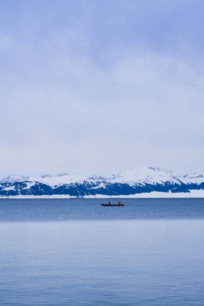 istock Serene winter lake with snowy mountains. 2192954307