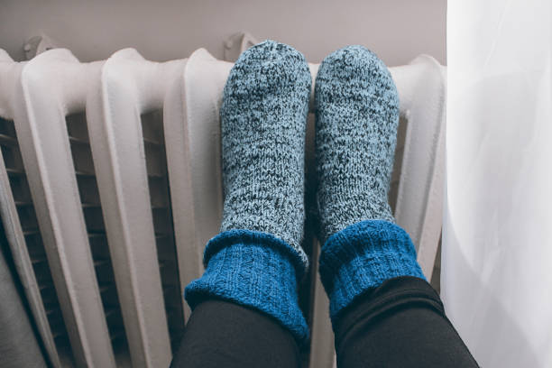 istock cast iron heating radiators, knitted socks with radiators, women's feet 2192955622