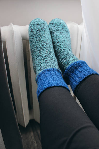 istock cast iron heating radiators, knitted socks with radiators, women's feet 2192955625