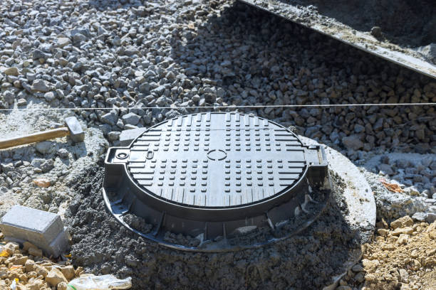 istock Concrete is being placed to secure forming top border of a manhole for utility pit 2192960483