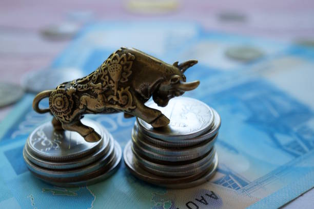 istock A bull statuette with coins and banknotes. Financial success. 2192963568