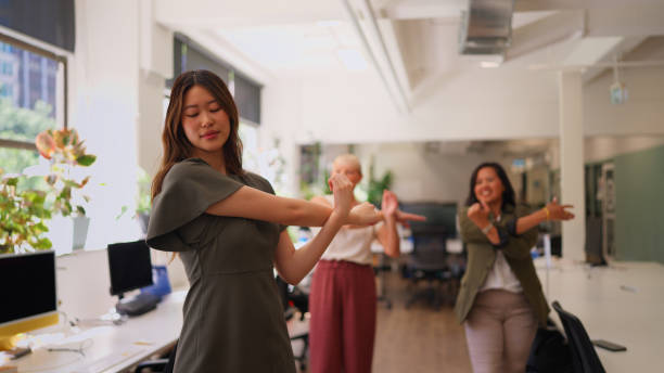 Professional Businesswomen Stretching During Break in a Green Office