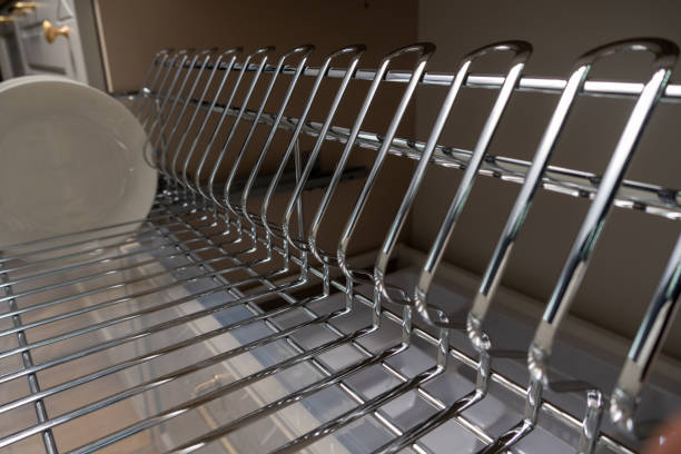 istock A clean and organized kitchen setup featuring a chrome dish rack with plates and cups. 2192970102