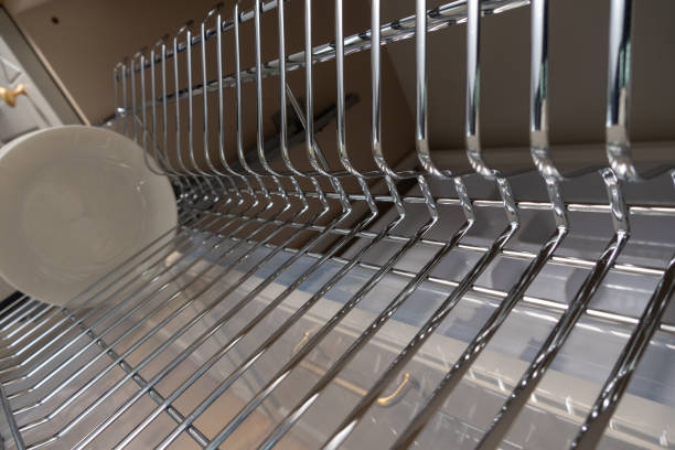 istock A clean and organized kitchen setup featuring a chrome dish rack with plates and cups. 2192970114