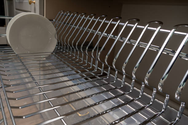 istock A clean and organized kitchen setup featuring a chrome dish rack with plates and cups. 2192970121
