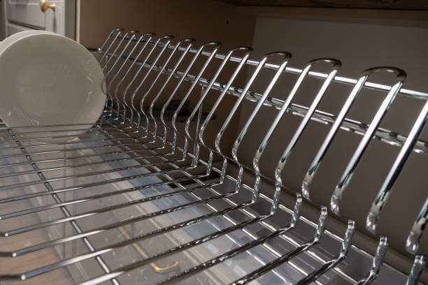 istock A clean and organized kitchen setup featuring a chrome dish rack with plates and cups. 2192970321