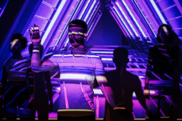 Person amidst neon projections in a futuristic vibrant environment with glowing patterns