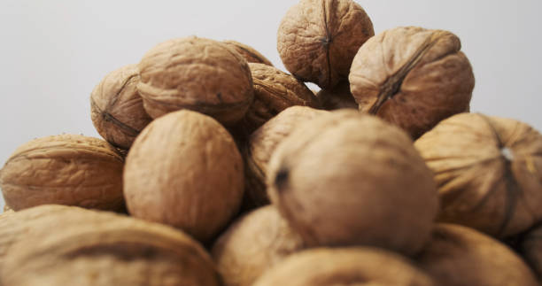 istock Unshelled fresh walnuts with hard textured shells in a heap, side view. Pile of nuts 2192973149