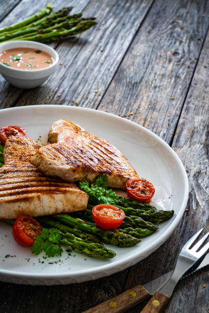 istock Barbecued turkey meat and asparagus on wooden table 2192975310