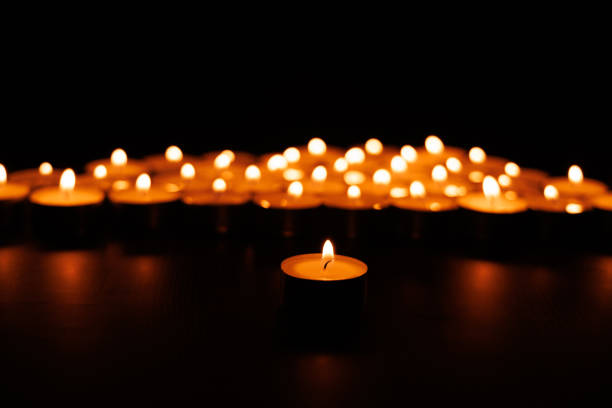 istock Peaceful lit candle glowing with blurred background candles in dark 2192975336