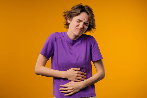 istock Young woman squeezing belly with hands. abdominal pain, suffering stomach ache 2192979587