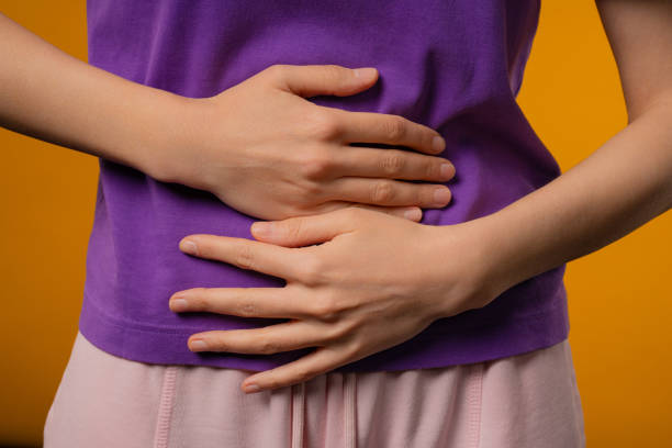 istock Young woman squeezing belly with hands. abdominal pain, suffering stomach ache 2192979603