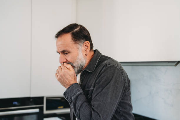 istock Mature man coughing in the kitchen 2192980374