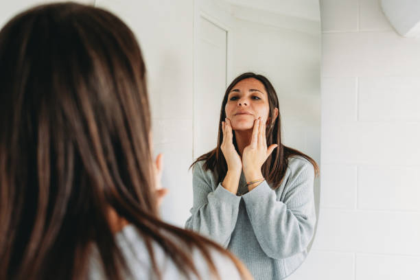 istock Woman checking her face skin in the bathroom mirror 2192983073