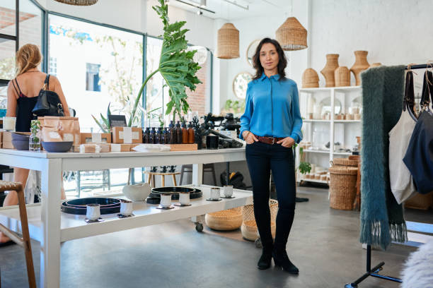 istock Young Asian entrepreneur standing by a table in her store 2192985580