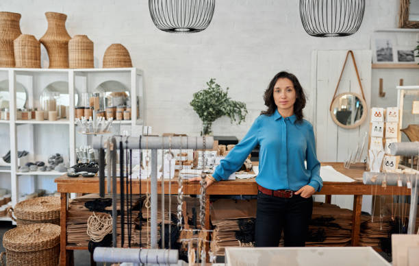 istock Young Asian entrepreneur standing by a counter in her store 2192985750