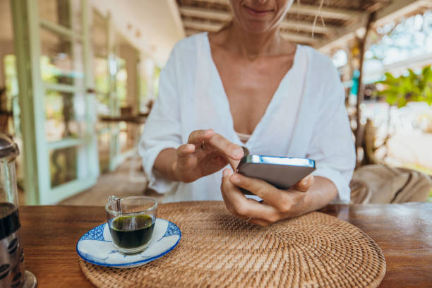 Woman Using Smartphone at Outdoor Cafe with Espresso