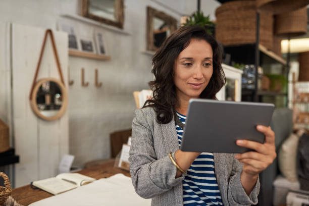 istock Smiling Asian woman working on a tablet in her store 2192986894