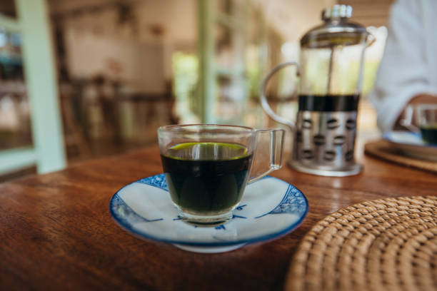 Glass Cup of Freshly Brewed Coffee on a Wooden Table in a Cafe
