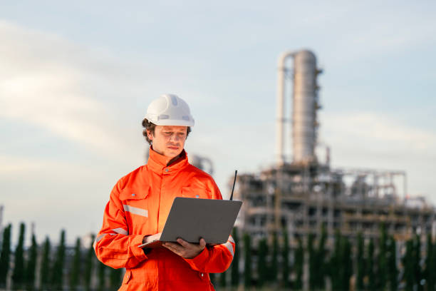 istock Industrial professional in safety attire analyzing refinery operations using modern technology, showcasing leadership and expertise in industrial safety and infrastructure projects. 2192987840