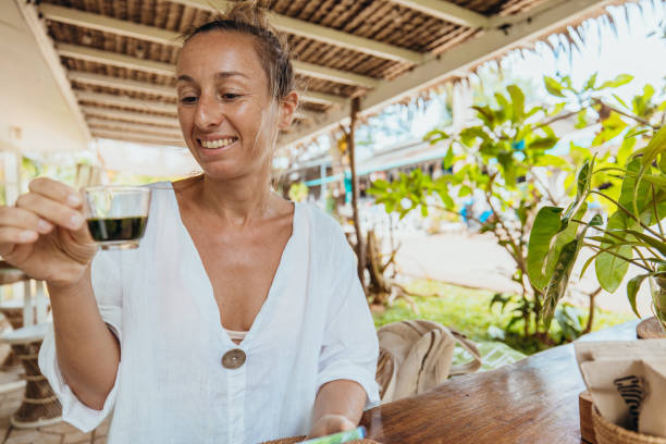 Woman Enjoying a Drink in Rustic Outdoor Setting
