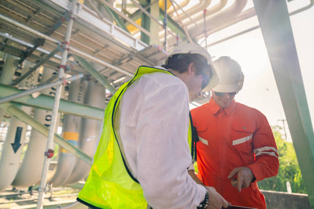 istock Professional engineers in vibrant safety attire inspecting a secure pipeline area, showcasing collaboration, operational excellence, and adherence to safety protocols. 2192988447
