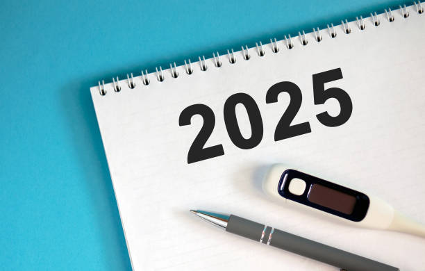 istock New year 2025 concept. Text on a notebook with a pen and a thermometer 2192996303