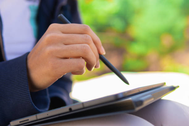 istock Close up of a young woman's hands using a tablet on location 2192996973