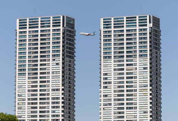A plane is currently flying securely between two tall, impressive buildings in a bustling metropolitan area filled with skyscrapers