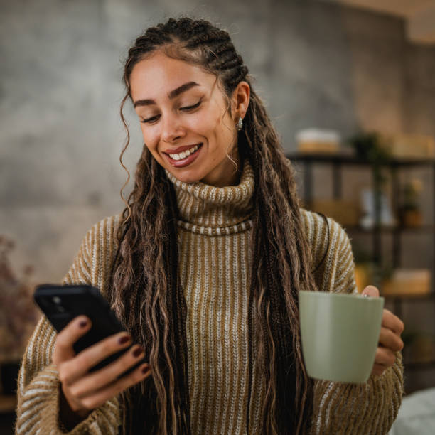 istock young woman use mobile phone and drink coffee at cozy home setting 2192999773