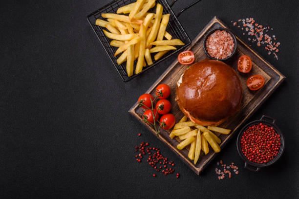 istock Delicious burger with beef patty, fried egg, bacon, herbs, sauce, salt and spices 2193005027
