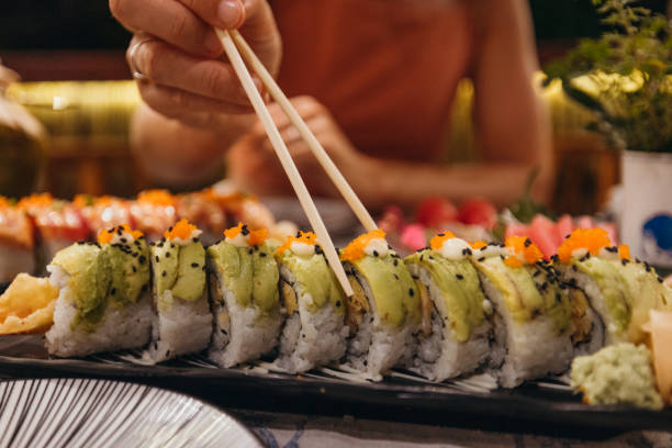 istock Person Enjoying Sushi at a Japanese Restaurant 2193006514