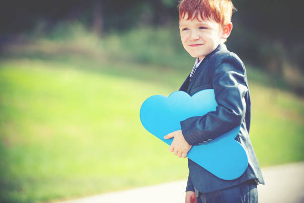 Portable Cloud computing concept. Child businessman is carrying a cloud . He is dressed in a suit and tie.