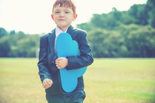 Portable Cloud computing concept. Child businessman is carrying a cloud . He is dressed in a suit and tie.