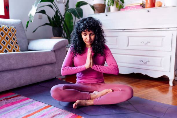 istock Hispanic woman practicing yoga and meditating at home 2193009066