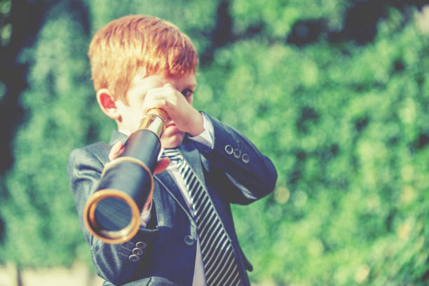 istock A child in a business suit looking through a telescope 2193009510