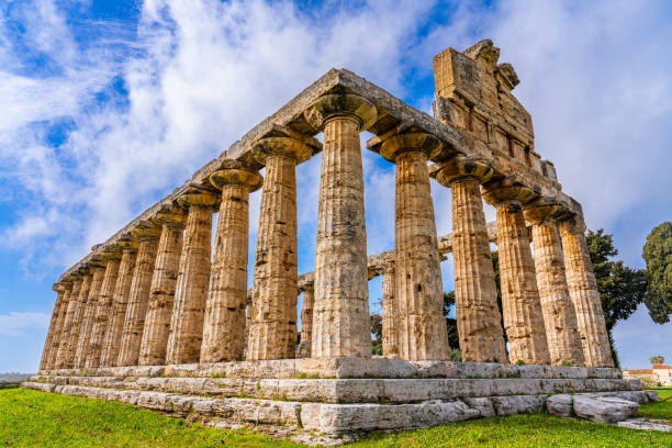 Paestum, Italy, 24 March 2024 - Tourists visiting the Picturesque, archaeological ruins of Temple of Athena featuring classical Greek architecture.