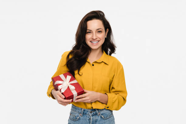 istock Smiling woman holding red present gift box with white ribbon bow looking at camera posing isolated 2193010568