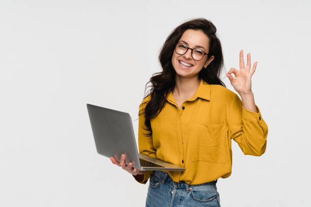 istock Young woman student worker using laptop for remote work show ok okay sign isolated white background 2193010739