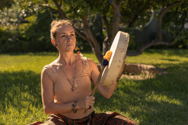 young woman playing shamanic drum