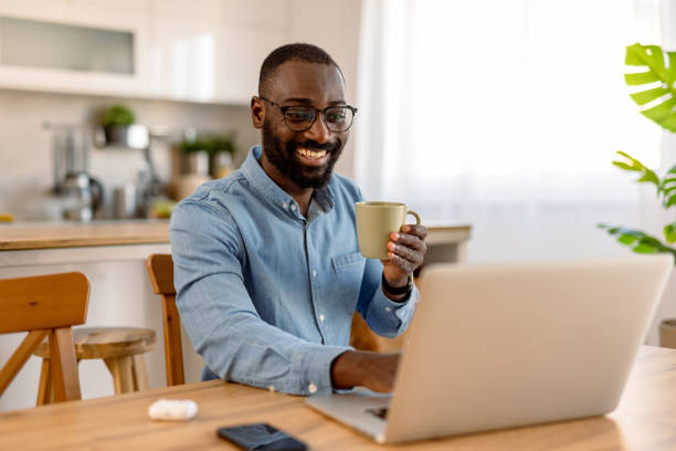 istock Happy young black man working from home drinking coffee 2193017306